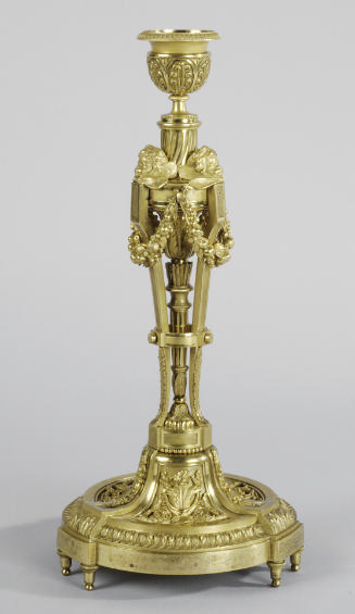 Gilt bronze candlestick with cherub heads and swags of garland