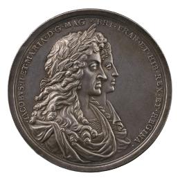 Silver portrait medal of King James II with a laurel wreath in his long, curling hair, wearing …