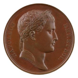 Bronze medal of a man in profile to the right with short hair and a laureate