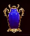 Blue porcelain and gilt bronze mounted vase against a black background