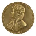 Gilt bronze medal of a man in profile to the left wearing a cravat, a sash, and a high-collared…