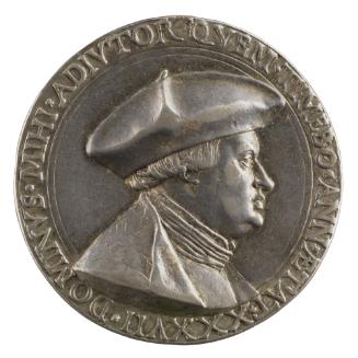 Silver medal of a man wearing a biretta, a damask coat, and a soft shirt forming several folds …