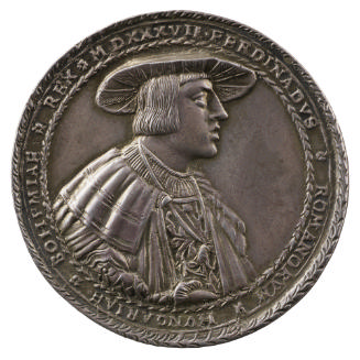 Silver medal of a man wearing a broad hat, pleated shirt, wide-collared cloak, and the badge of…