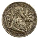 Silver medal of Charles V wearing full armor and holding a scroll in his right hand and a sword…