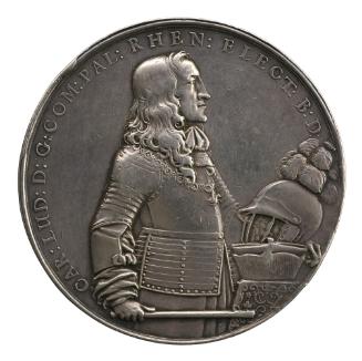 Silver medal of a standing man facing the right and wearing armor, cravat, and Order of the Gol…