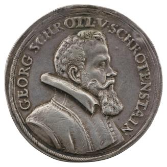 Silver medal of a man in profile to the right