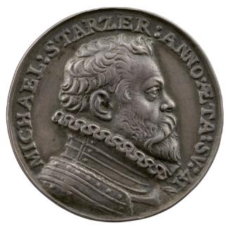 Silver medal of a man with mid length hair and a beard, wearing armor and a high ruff collar