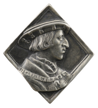 Silver medal of a man wearing a cap and a coat with a fur collar