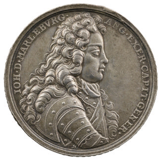Silver medal of a man in profile to the right wearing a wig, armor, and a sash across his breas…