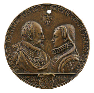 Bronze medal of a man and woman in profile facing each other. The man is balding and bearded, a…