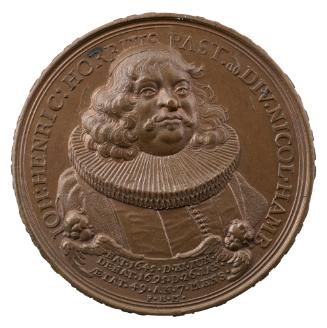 Bronze medal of a man wearing a skullcap, ruff, and ecclesiastical gown