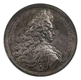 Silver medal of man wearing a wig in profile to the right