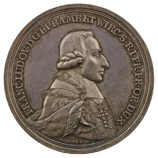 Silver medal of a man in profile to the right