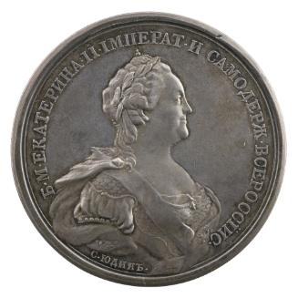 Silver medal of a woman wearing a laurel and a scale harness with a draped mantle