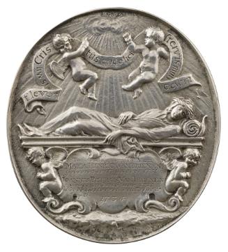 Silver medal depicting two flying genii, nude, pointing toward the clouds from which rays of su…