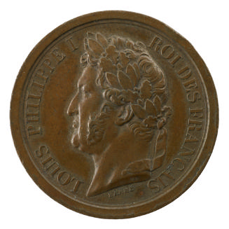 Bronze medal of a man in profile to the left wearing a wreath of laurels