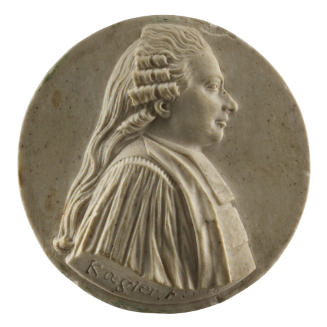 Stone medal of a man in profile to the right wearing a gown