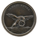 Bronze medal of an eagle holding a disproportionately large ring in its beak and talons