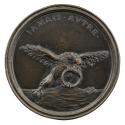 Bronze medal of an eagle holding a disproportionately large ring in its beak and talons