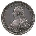 Silver medal of a woman in profile to the left wearing earrings, pearl strands woven throughout…