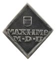 Silver medal depicting a shield and two lines of inscription