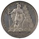 Silver medal depicting a man grasping a tree with his right hand, while his left rests upon a s…