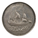 Silver medal of a large warship, sails full of wind, accompanied by Tritons (sounding seashells…