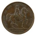 Bronze medal of a man on horseback facing the right, holding the reins in his left hand and a s…