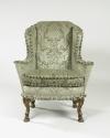 Side view of winged armchair upholstered in light green silk with a damasque motif