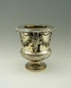 Gold and silver wine cooler with plant designs and rams' heads, side view