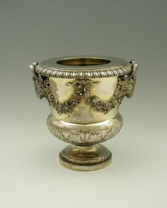 Gold and silver wine cooler with plant designs and rams' heads