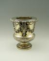 Gold and silver wine cooler with plant designs and rams' heads, side view