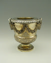Gold and silver wine cooler with plant designs and rams' heads