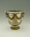 Gold and silver wine cooler with plant designs and rams' heads