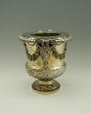 Gold and silver wine cooler with plant designs and rams' heads, side view