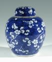 Single blue porcelain covered jar decorated with white floral decorations.