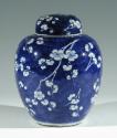 Single blue porcelain covered jar decorated with white floral decorations.