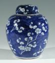 Single blue porcelain covered jar decorated with white floral decorations.