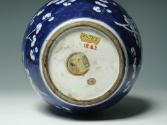 Single blue porcelain covered jar decorated with white floral decorations, bottom of jar.