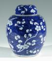 Single blue porcelain covered jar decorated with white floral decorations.