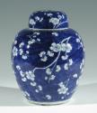 Single blue porcelain covered jar decorated with white floral decorations.