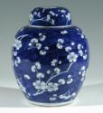 Single blue porcelain covered jar decorated with white floral decorations.