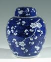 Single blue porcelain covered jar decorated with white floral decorations.