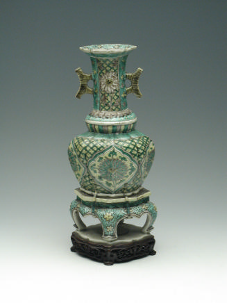 Porcelain jar with legs and long neck with handles, with green, blue, and yellow pattern decora…