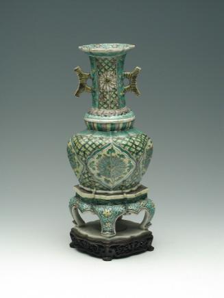 Porcelain jar with legs and long neck with handles, with green, blue, and yellow pattern decora…