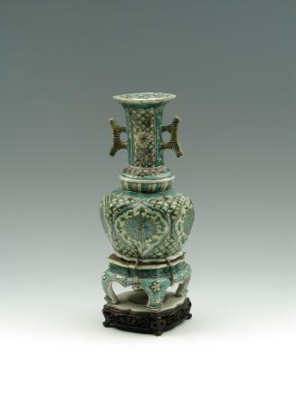 Porcelain jar with legs and long neck with handles, with green, blue, and yellow pattern decora…