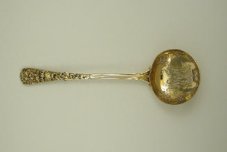 Gilt silver ladle with intricately designed handle and bowl