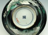 View of bottom of porcelain bowl with flaring ring and black ground with vegetal designs