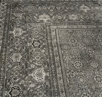 Black and white image of corner portion of Persian carpet with floral design