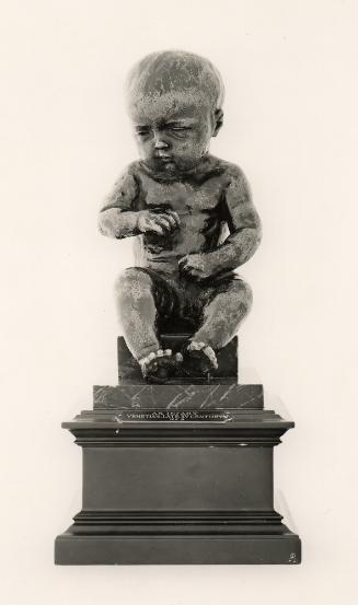 Bronze sculpture of a seated child.